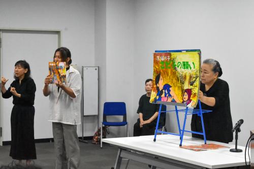 紙芝居を読む中村 竜也さんと、大型紙芝居のめくりを担当する由利江さん