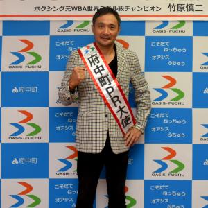 大使証交付式での竹原慎二さんの写真
