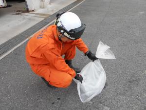 ゴミ袋に水を入れてくくる様子