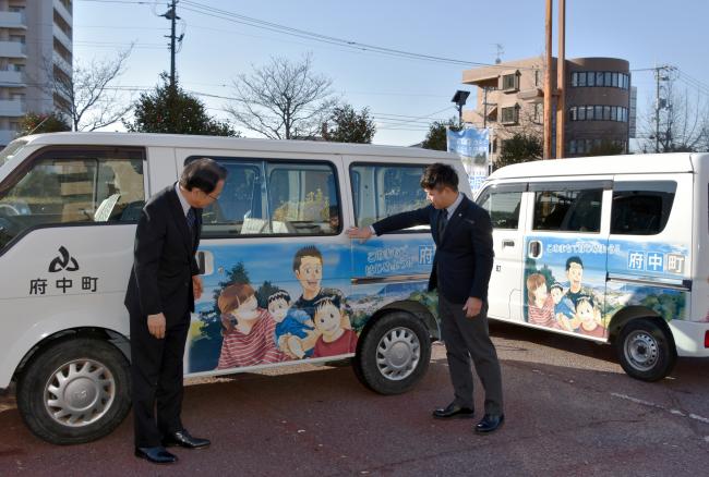 プリント車両を見ながら話す佐藤町長と堀越車体株式会社 代表取締役 十川 孝行さんの写真